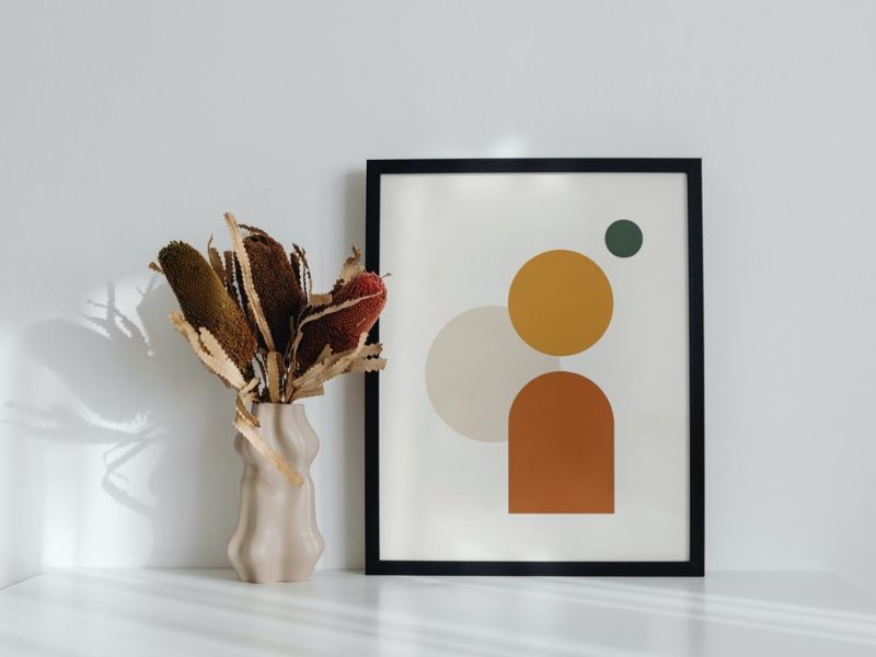 DIY wall art: framed geometric canvas art paired with a modern vase of dried flowers