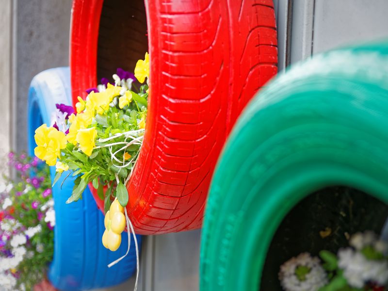 DIY garden projects: vibrant painted tire planters with colorful flowers, adding charm to outdoor spaces