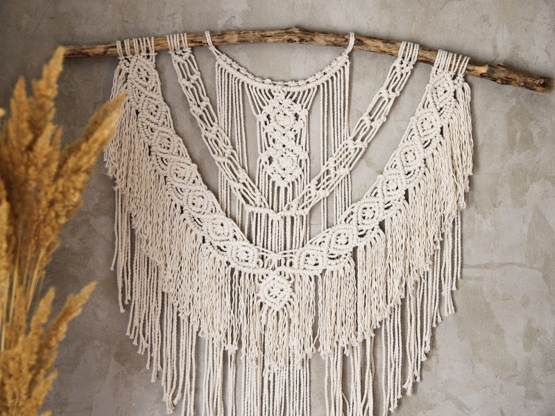 DIY wall art: intricate macramé wall hanging displayed on a beige wall