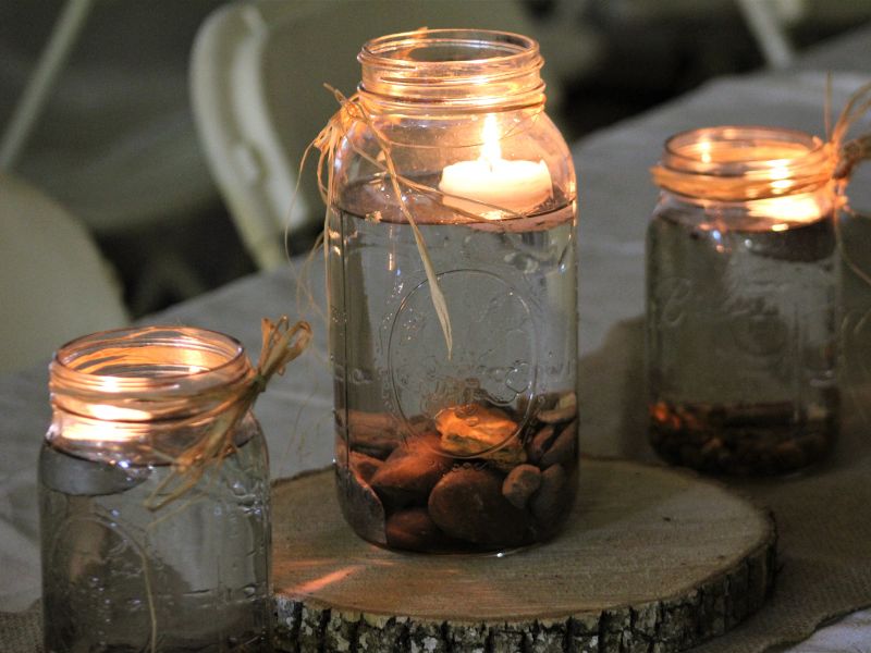 DIY garden projects: mason jar lanterns with floating candles and decorative stones, creating a warm, rustic outdoor glow