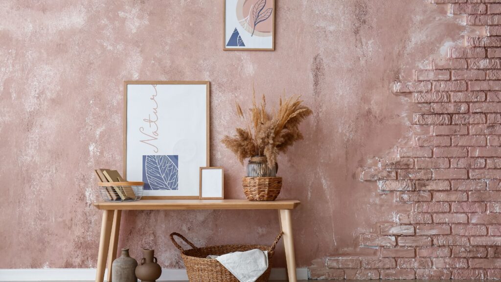 DIY wall art: textured pink wall with framed nature-inspired artwork and rustic decor for a creative home aesthetic