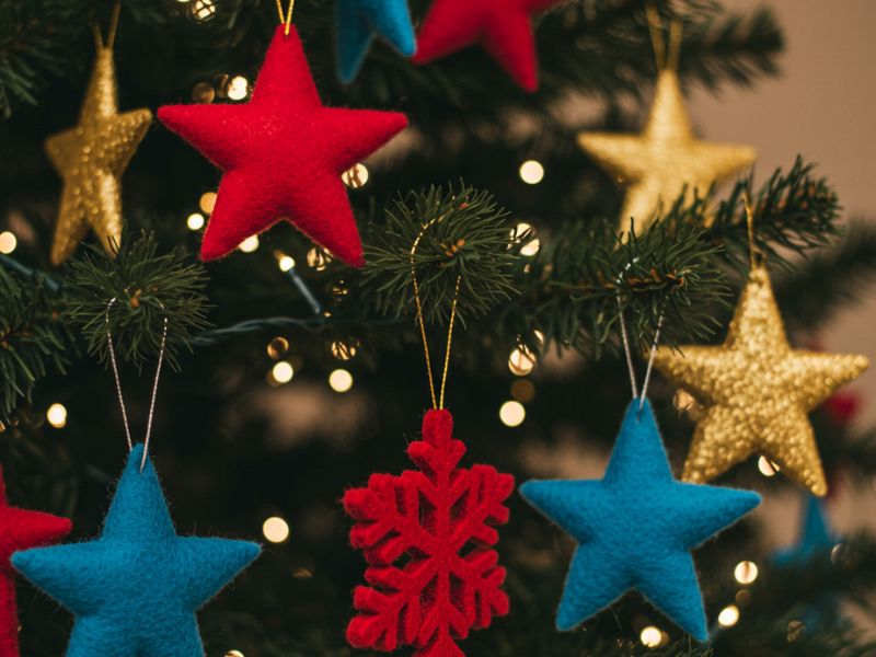 holiday diy projects: colorful felt star and snowflake ornaments on a Christmas tree