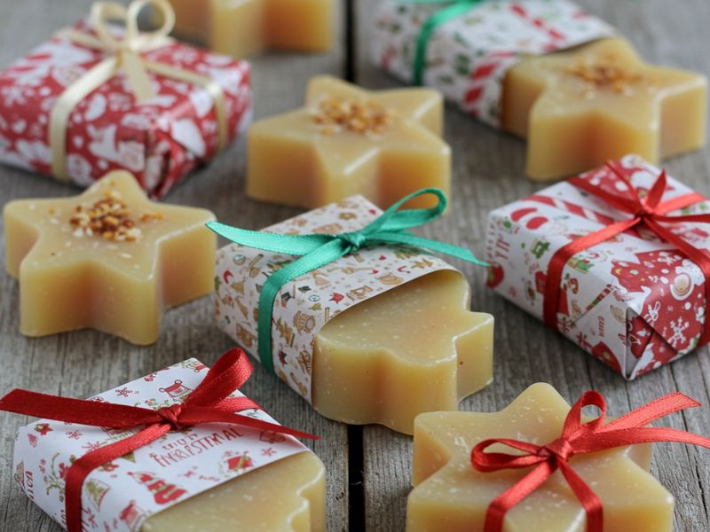 diy holiday gifts: wrapped holiday soap bars shaped like stars, decorated with festive ribbons and holiday-themed paper wrapping